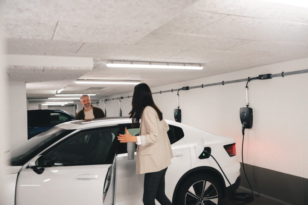 kvinna och man i garage med elbil och laddboxar