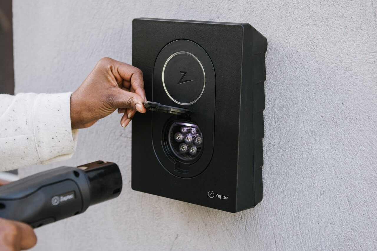 Händer som för in laddkabel i en öppnad laddbox