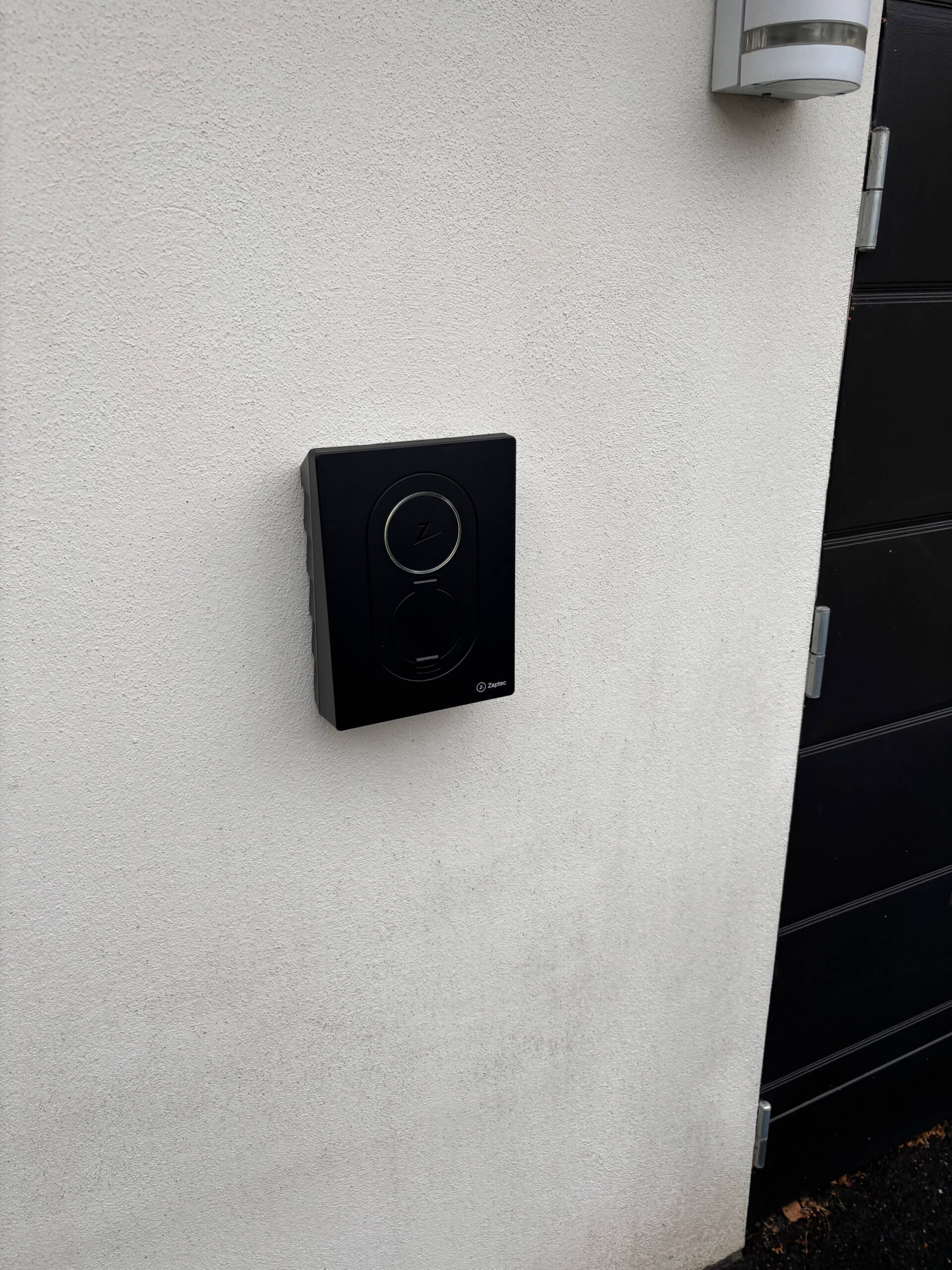 Zaptec Go installation i Nacka på vit fasad till garage